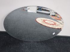 An oval un-framed mirror