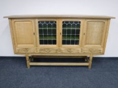 A blonde oak sideboard on trestle base
