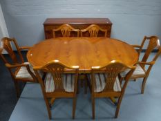 A reproduction yew wood twin pedestal dining table and six chairs