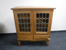 A continental light oak glazed door cabinet