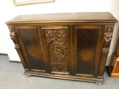 An early twentieth century carved oak triple door sideboard