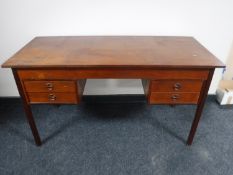 A mid 20th century teak desk fitted with four drawers