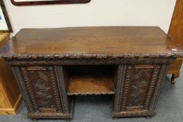 A late Victorian carved oak pedestal desk