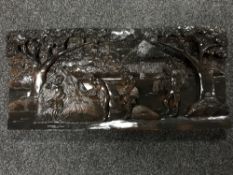 A carved Eastern plaque depicting figures harvesting