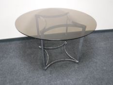 A circular smoked glass topped dining table on metal pedestal by Merrow Associates