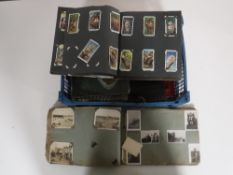 A basket of cigarette card albums and cards