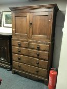 A Victorian pine press fitted with double door cupboard above and five drawers below,