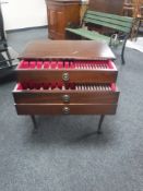 A mahogany three drawer cutlery chest containing Community cutlery