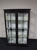 An antique mahogany display cabinet bearing perfume advertising