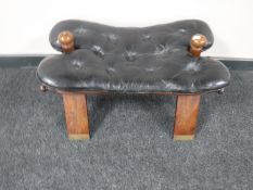 A mahogany camel stool and black button leather saddle