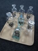 Seven glass chemist bottles with sign writing labels