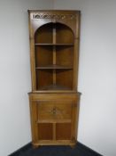 A carved oak corner cupboard