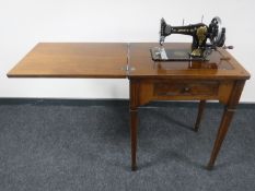 A Singer hand sewing machine in mahogany table