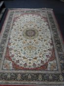 A silk finished machine made fringed floral rug on red ground