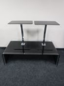 A contemporary two tone glass coffee table and a pair of black glass and metal side tables