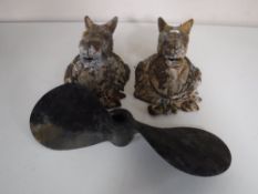 Two cast iron horse head hitches together with a cast iron propeller