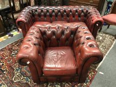 A red leather Chesterfield three-seater settee,
