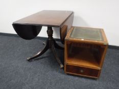 A mahogany pedestal drop leaf table with a brass inlay leather topped side table