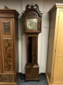 A Grandfather clock in carved oak case, with brass and silvered dial, with pendulum and weights,