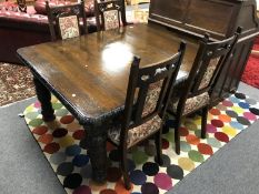 A 19th century carved oak pull out dining table together with a set of later high backed chairs (5)