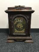 A carved oak chiming bracket clock with brass dial