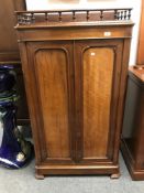 A Victorian mahogany double door cabinet fitted with four linen trays and rail top,
