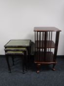 A nest of three leather topped tables and revolving book stand