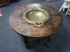 An early 20th century circular oak coffee table inset brass bowl