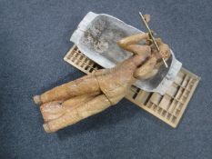 A carved wooden figure playing a flute,