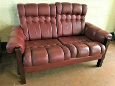 A wood framed Burgundy leather settee