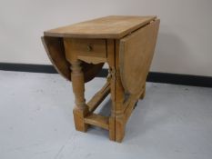A blonde oak drop leaf coffee table fitted a drawer