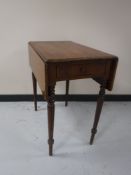 A Victorian mahogany flap sided table on reeded legs fitted a drawer