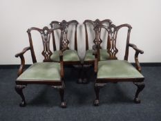 A set of four George III style carved mahogany dining chairs on claw and ball feet
