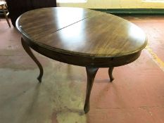 An early twentieth century oval mahogany dining table on cabriole legs