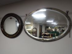 An early 20th century oval framed mirror and a mahogany oval framed mirror