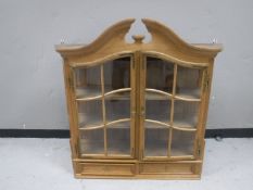 An early twentieth century continental oak glazed door wall cabinet fitted two drawers