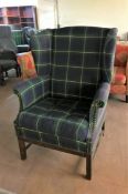 A twentieth century wing back armchair upholstered in a tartan fabric