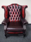 A oxblood leather Chesterfield wing back armchair