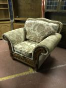 A wood framed armchair upholstered in a floral fabric