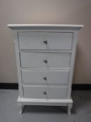 A contemporary white four drawer chest