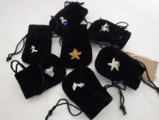 Seven Swarovski lapel pins in cloth bags