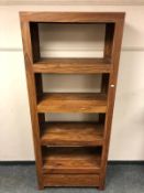 A contemporary hardwood bookcase fitted with a drawer,