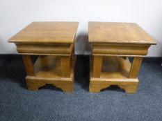 A pair of oak two tier lamp tables