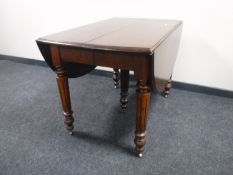 A Victorian mahogany flap sided dining table and two extension leaves