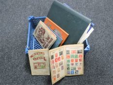 A basket containing seven assorted mid 20th century stamp albums with stamps together with two