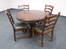 A heavy oak circular extending table on pedestal support and four ladder back chairs