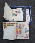 A basket containing seven assorted mid 20th century stamp albums with stamps