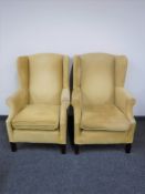 A pair of wingback armchairs in gold fabric