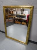 A gilt framed mirror and a an Ikea linen basket