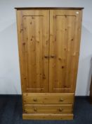 A pine double door wardrobe fitted with two drawers